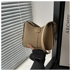Detail of khaki faux leather shoulder bag with gold 'FASHION' lettering and wide strap