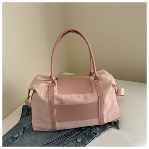 Macro detail of pink quilted travel bag showing textured fabric and smooth PU handles