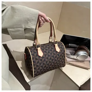 Détail du sac Boston avec motifs géométriques et finitions de bords rouges contrastés