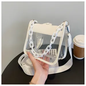 Detail of transparent PVC square bag with white plastic chain and fabric strap
