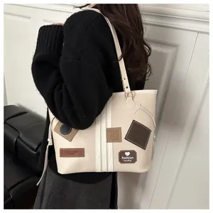 Detail of vintage tote bag with fashion lucky patches and smooth cream PU leather texture