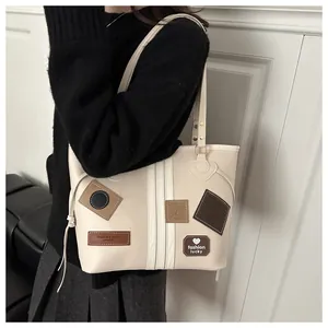 Close-up of cream PU tote bag with vintage patches and fashion letter embroidery detail
