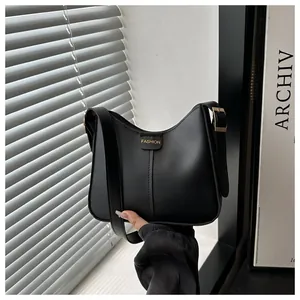 Close-up of the golden Fashion stamp and buckle detail on the black leather hobo bag