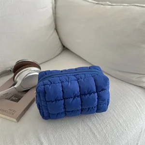 Quilted blue nylon makeup bag with a soft padded grid pattern and zipper closure