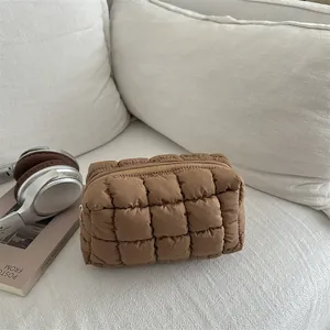 Brown quilted nylon toiletry bag with bubble texture on a sofa for travel storage