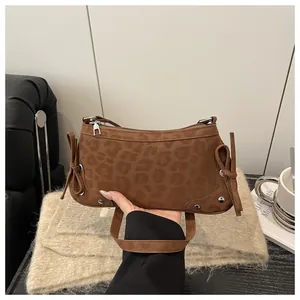 Detailansicht der Schultertasche mit Leopardenmuster, Seitenschleifen und Silbernieten