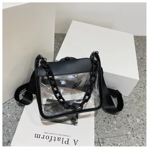 Close-up of transparent PVC square bag featuring thick black chain and leather trim