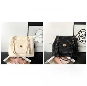 Détail de sacs plissés avec bandoulières chaînes et fermoirs rotatifs en beige et noir