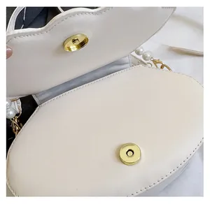 Detail of high-quality magnetic snap closures and smooth inner lining of the shell bag
