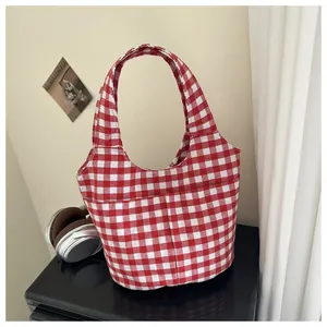 Detail of red and white checkered canvas tote bag with functional front storage pockets
