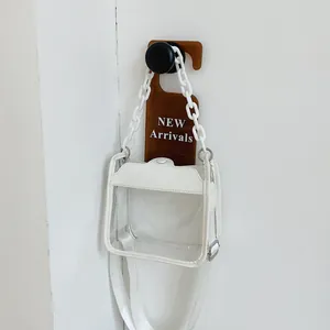 Minimalist transparent PVC crossbody bag with white chain and adjustable strap on white wall
