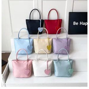 Detail view of colorful nylon tote bags with heart pendants in eight assorted colors