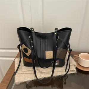 Vintage black PU tote bag with artistic patches and gold rivet details for women