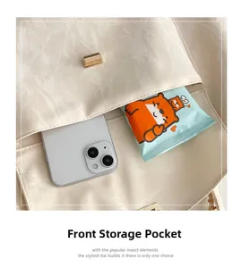 Gros plan du sac crème texturé montrant la poche avant fonctionnelle pour ranger un smartphone
