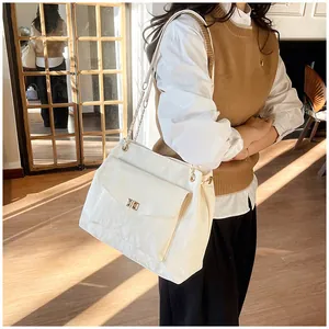 Détail du sac cabas blanc avec texture perlée et fermoir élégant en métal doré chic