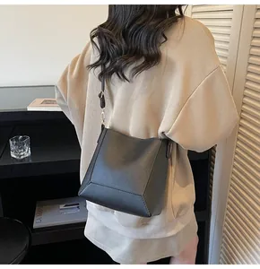 Back view of a minimalist black leather tote bag with adjustable shoulder straps and soft texture