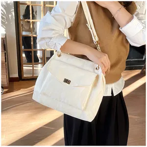 Détail du sac crème avec boucle rotative dorée et texture en similicuir pour femme élégante