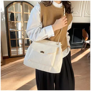 Détail du sac crème avec texture effet nuage et fermoir rotatif en métal doré chic