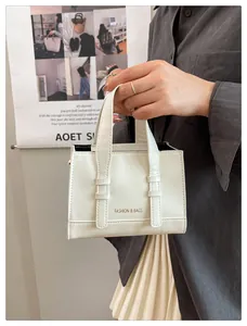 Detail of white leather handbag with FASHION & BAGS print and minimalist handles