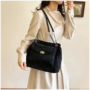 Détail du sac à bandoulière noir plissé avec fermoir doré et bandoulière chaîne