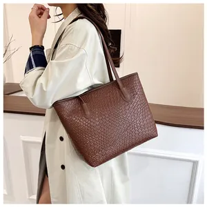 Detail shot of the deep brown tote bag featuring fine woven faux leather texture