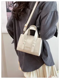Close-up of white leather handbag with gold buckles and Fashion & Bags inscription