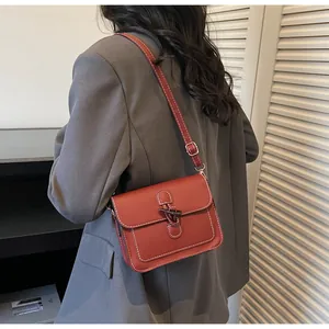 Close-up of vintage square bag with contrast stitching and unique horn buckle detail