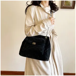 Détail du sac bandoulière noir plissé avec fermoir doré et élégante bandoulière chaîne