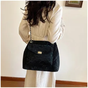 Détail du sac à bandoulière noir avec texture plissée et chaîne dorée pour femme