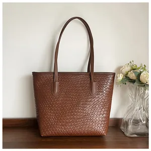Detailed view of brown woven texture on large tote bag placed on a wooden desk