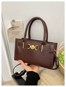 Detailed view of dark brown tote bag with gold heart clasp and premium matte finish