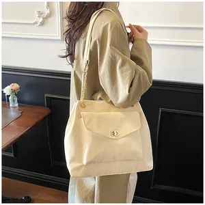 Sac fourre-tout crème avec bandoulière en chaîne dorée et détail de fermoir