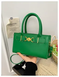 Close-up of bright green leather handbag featuring golden heart-shaped twist lock buckle