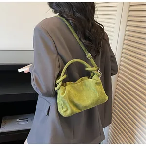 Detail of green faux suede crossbody bag with knotted handle and adjustable strap