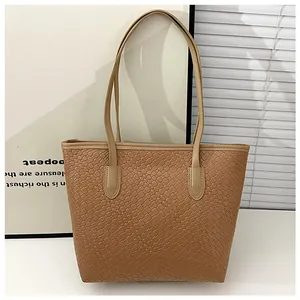 Detail of light brown woven texture and slim handles on a chic tote bag for daily commute