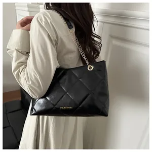 Détail du sac cabas en cuir matelassé noir avec chaîne dorée et logo Fashion
