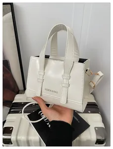 Macro detail of creamy white PU leather handbag with Fashion & Bags text and gold hardware