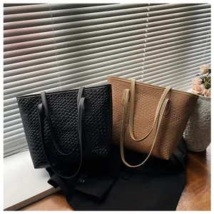 Detail of woven texture on large tote bags in black and khaki colors by window