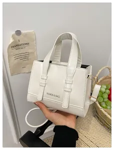 Detailed shot of white PU leather bag featuring Fashion & Bags logo and slim strap