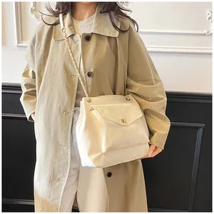 Détail du sac à bandoulière ivoire avec texture plissée et chaîne en métal élégante