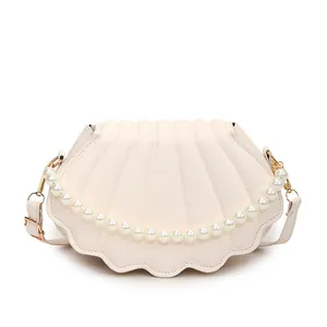 Elegant shell-shaped crossbody bag in cream PU leather with pearl chain and gold hardware