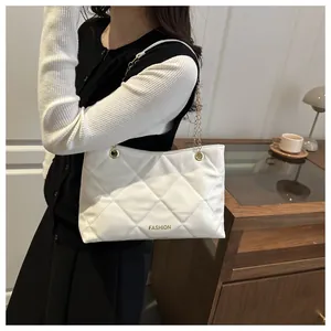 Vue détaillée du sac cabas blanc matelassé avec chaîne dorée dans un décor intérieur