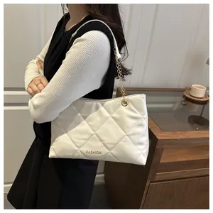 Détail du sac cabas matelassé blanc avec logo FASHION doré et bandoulière chaîne métal