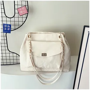 Détail du sac à bandoulière blanc crème avec fermoir doré et texture de bandoulière