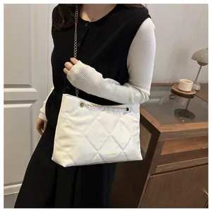Gros plan du sac cabas matelassé blanc avec chaîne dorée et inscription FASHION