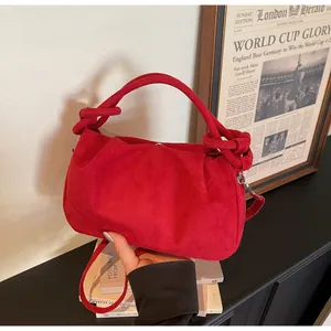 Close-up of red faux suede handbag with cloud pleats and knotted handle detail