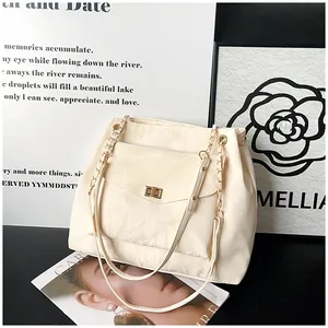Détail du sac cabas crème avec fermoir doré et décoration de fleur de camélia