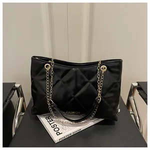 Détail du cabas noir matelassé avec chaîne dorée et texture en cuir de luxe