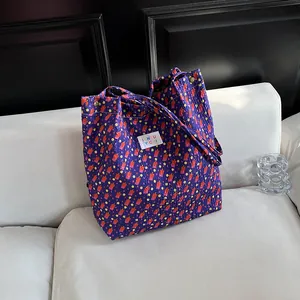 Deep purple floral bubble textured tote bag with colorful dots on a white sofa