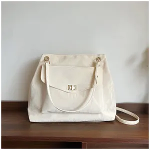 Détail du sac crème à texture plissée avec un fermoir rotatif doré élégant